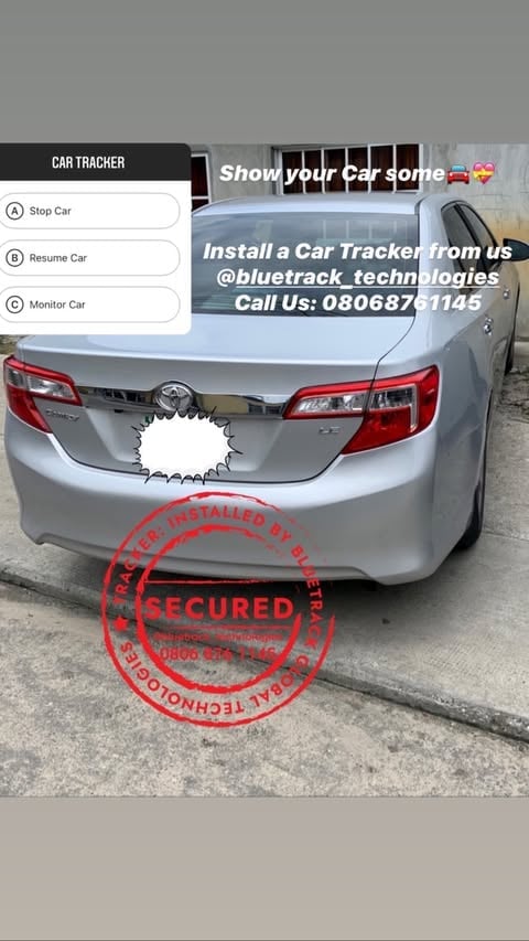 Silver sedan parked with car tracker app interface showing stop, resume, and monitor car options and promotional text advertising GPS tracking installation services