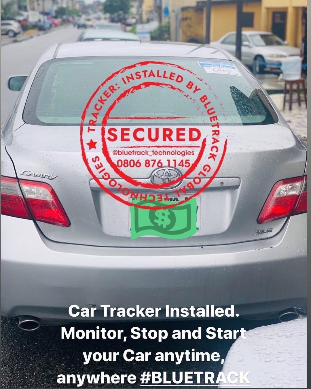 Silver sedan with red circular SECURED stamp and green tracking device stamp on trunk, promoting car tracker installation service